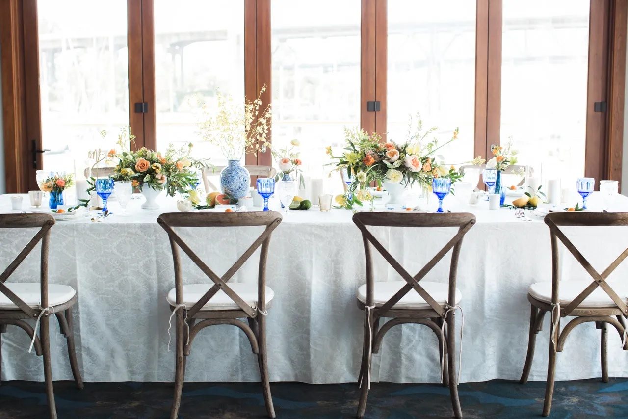 The dressed reception table at Tap & Barrel · Bridges, with the Burrard Bridge and False Creek visible through the windows.